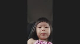Little girl taken dad's phone selfie and filming herself in car