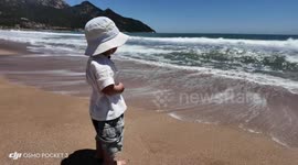 Toddler tumbles on beach after tiny wave came in Shandong, China