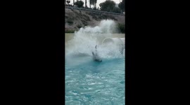 Alicante, Spain - June 13, 2025: Thrilling water slide experience as a person splashes into a swimming pool, showcasing excitement and fun at a Terra Natura Water park