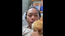 Cat bites owner's chin as he tries to sing her a lullaby