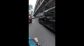 Luggage falls from the back of van on road in Bangkok