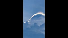 Shimmering cloud iridescence seen shining above fields in Thailand