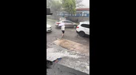 Man shields child from hailstorm under umbrella in Guizhou, China
