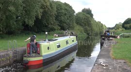 A canal boat goes through a lock on the forth and clyde canal