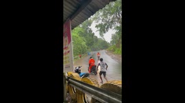 Motorcycle rider takes a tumble on wet road