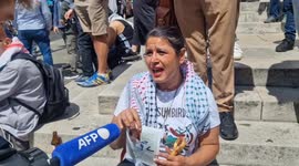 Palestinian refugee holds up only proof of her identity at Palestine protest in London