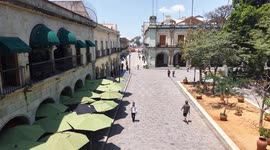 Oaxaca de Juárez, a city in central Mexico, features colonial buildings, many of which are in the Zócalo, the central square, and the Government Palace, with colorful murals depicting regional history. The Alameda de León square faces the ornate facade of