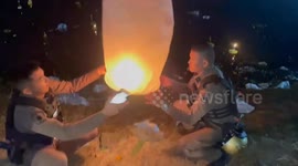 Policemen have hilarious sky lantern release fail when it falls into pond