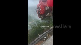 Moment of highway bridge collapse: truck left hanging over the abyss.
