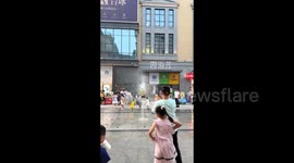 The traffic cone, lifted by a fountain, attracted the attention of the surrounding children.