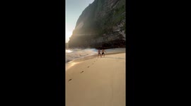 Tourists knocked over by wave crashing onto beach in Bali