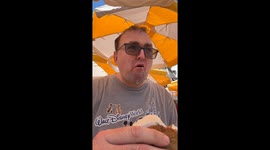 Middle age man eats an ice cream sandwich at Magic Kingdom in Walt Disney World