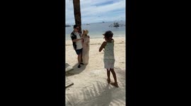 Beach kid instructs tourists how to pose for holiday snaps