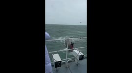 Passing ferry rescues fisherman from capsized boat during storm