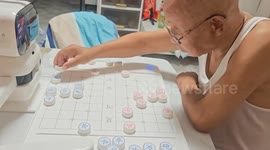 Robot faces off with elderly man in a game of Chinese chess