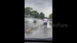 Elderly cyclist wields brick to prevent passing cars from splashing him with puddle