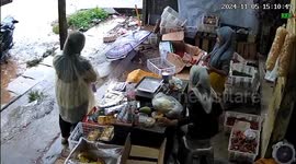 Two women startled by thunder at fruit store in Tangerang, Indonesia