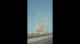 Dust devil crosses busy highway in San Tan Valley, Arizona, USA
