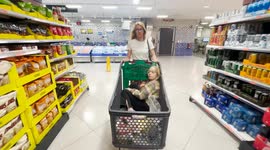 Mother shopping with daughter in large supermarket.