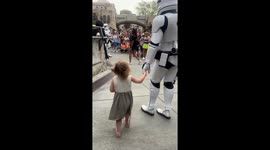 Young girl holds hands with stormtrooper in magical Disney moment