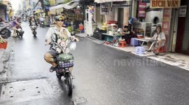 Dog in Baby Carrier Rides Electric Bike Through Vietnam Traffic