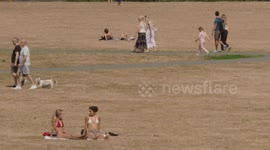 Members of the public sunbathe and relax during hot and sunny weather in Greenwich Park in South East London