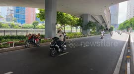 Two Men Sleep on Motorbikes Beneath Bridge in Busy Ho Chi Minh City