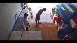 The man got wet as he used a net to catch fish in the aquarium