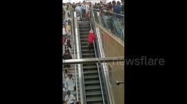 Stubborn woman determined to walk wrong way up escalator causes congestion