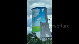 Workers paint blue sky and clouds onto 200-metre-tall power plant cooling chimney in China