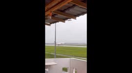 Plane balances on a single wheel as it lands during storm