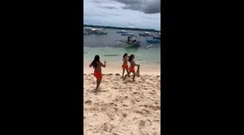 Beachgoer red-faced to find two other visitors in identical orange bikinis