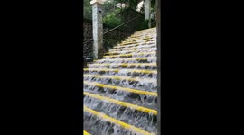 Storm turns steps into waterfall as student poses for graduation pictures