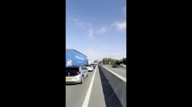 Complete traffic standstill on the M1 near Milton Keynes with cars at a full stop as thick black smoke looms ahead.