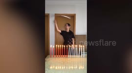 Martial artist extinguishes candles and slices bottle caps with nunchaku