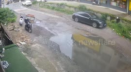 Motorcycle crashes into parked car while avoiding puddle in Hunan, China