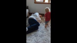 The young boy ran away with his blanket before he hit a wall.