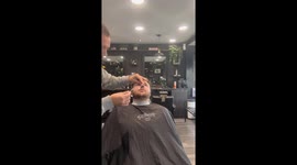 Tense moment: Barber struggles to remove nose wax strip stuck in client's nose
