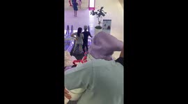 Pampered pet dog wrapped in clothes is carried around mall