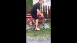 Man struggles to pedal bicycle until friend helps in Belitsa, Belarus