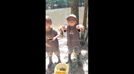 Twin boys show off their catch during fishing trip in North Alabama, USA