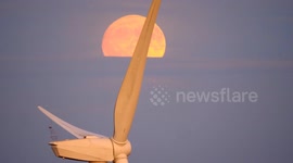 Spectacular full Buck Moon rising over wind turbines in the Derbyshire Dales,