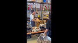 Tourist having Thai cooking lessons throws rice over classmate
