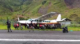 Airport staff push plane that skidded off runway due to burst tyre