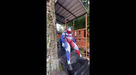 Chubby tourist dressed as Ultraman rides zipline