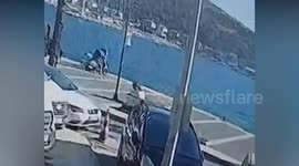 Rider struggling to start scooter parked at marina shoots straight into sea