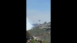Aircraft drop water amid thick smoke during Laguna Beach fire in California, USA