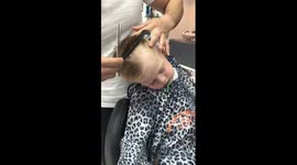 Adorable toddler struggles to stay awake while getting a hair cut