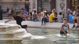 People play in Buckingham Palace fountain to cool down