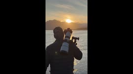 Videographer captures stunning footage of brown bear catching salmon in sunset